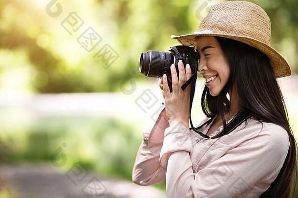 <strong>摄影课</strong>。年轻的亚洲女学生在户外用数码相机拍照