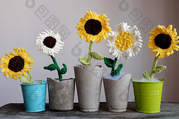 桌上令人惊叹的五个花瓶，由纱线编织而成，白色和黄色的向日葵，绿色的叶子在罐子里，非常适合装饰