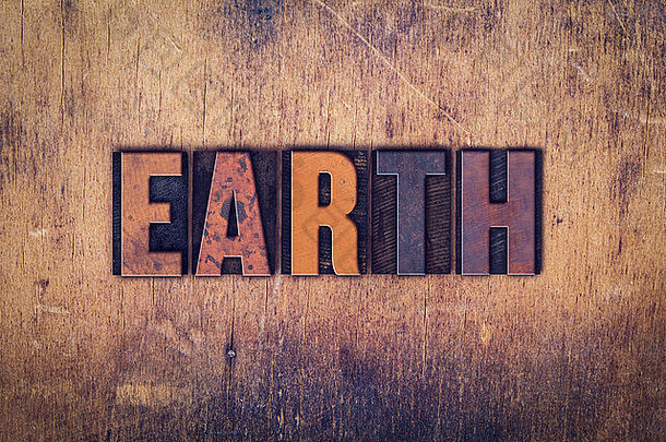 “地球”一词是在一个陈旧的木制背景上用肮脏的复古活版印刷字体写的。