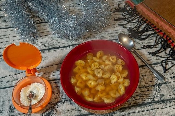红色的碗里盛满了美味的肉汤玉米饼，这是意大利料理的典型菜肴，可以保护自己免受寒冷天气的侵袭