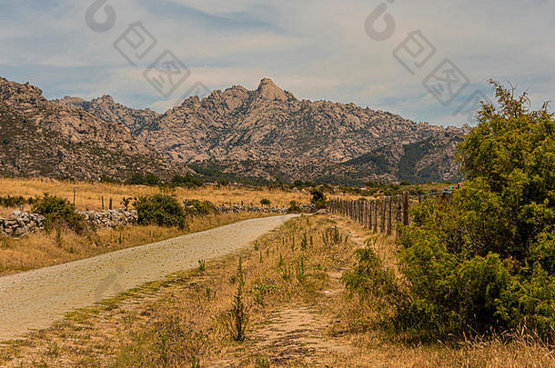 以瓜达拉马山脉的落基山脉为背景的乡村道路。西班牙马德里