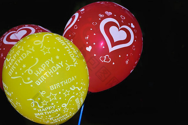 一套粉红色、绿色和红色的飞行气球。飞行生日氦气球。在黑色背景上隔离。党的庆祝活动是一个概念。