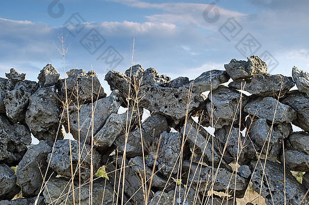 草坪或田野里的某个地方的旧石<strong>墙</strong>。