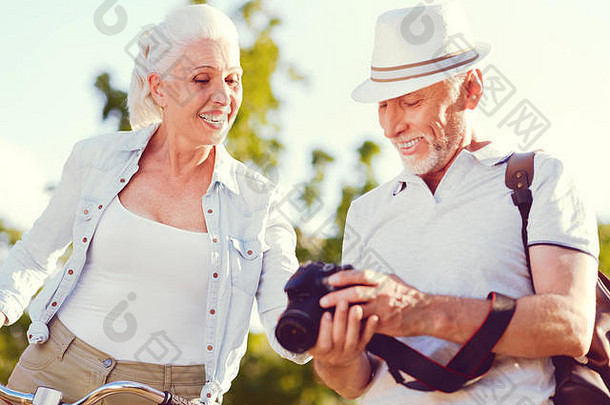 容光焕发的老年夫妇一边看照片一边微笑