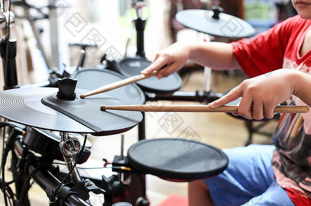 身份不明的亚洲男孩玩电子鼓电子鼓