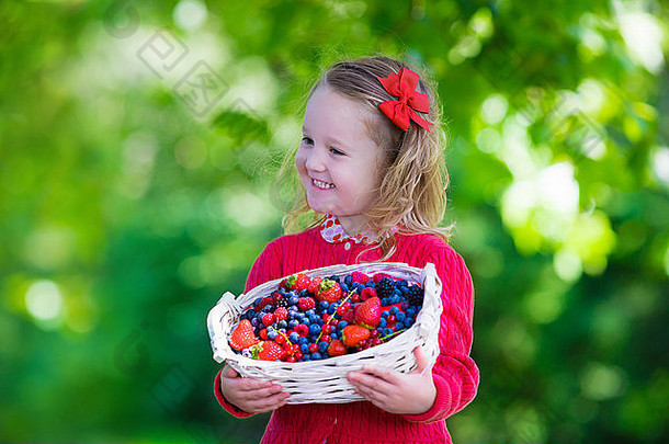 在农场采摘浆果的孩子。小女孩吃草莓、覆盆子、蓝莓、黑莓、红醋栗和黑醋栗。