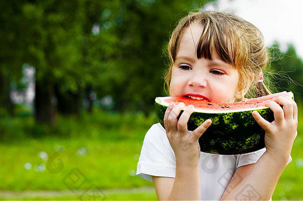 夏天，可爱的小女孩在公园里吃西瓜