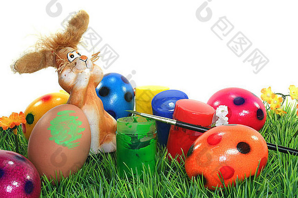 复活节兔子在有颜色和蛋的花草坪上