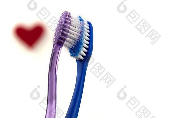在白色背景上分离出一对粉红色和蓝色的牙刷。情人节的爱情观