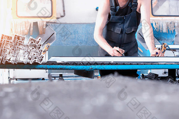 生产PVC窗时，工人将尺寸记录在框架PVC、毛毡笔臂的轮廓上