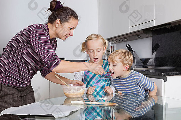 母亲和孩子们在<strong>厨房</strong>里烤烤饼干面糊
