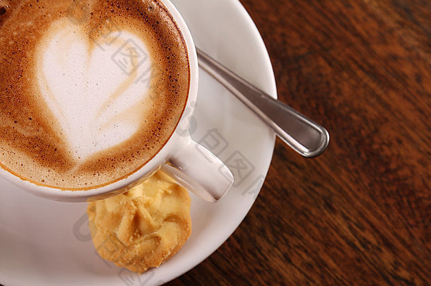 美味的芳香卡布奇诺咖啡白色瓷杯饼干一边木表格图像复制空间