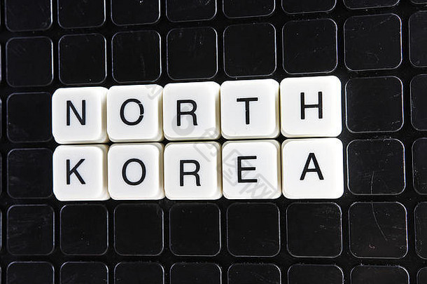 朝鲜文字填字游戏。字母块游戏纹理背景。黑色背景上的白色字母。白色教育玩具块与文字。