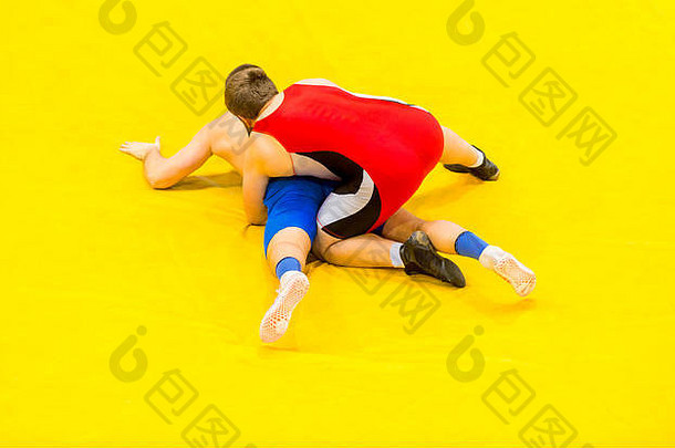 年轻的但蓝色的红色的摔跤黄色的摔跤地毯健身房