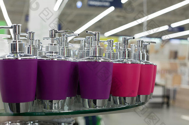 用于液体肥皂、浴室软膏和金属配件的皂盘分配器，颜色为紫色和粉色，放在商店的玻璃货架上，用于化妆品<strong>特卖</strong>