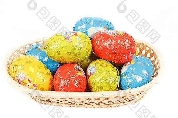 一个篮子里的复活节巧克力蛋被隔离在白色的地板上