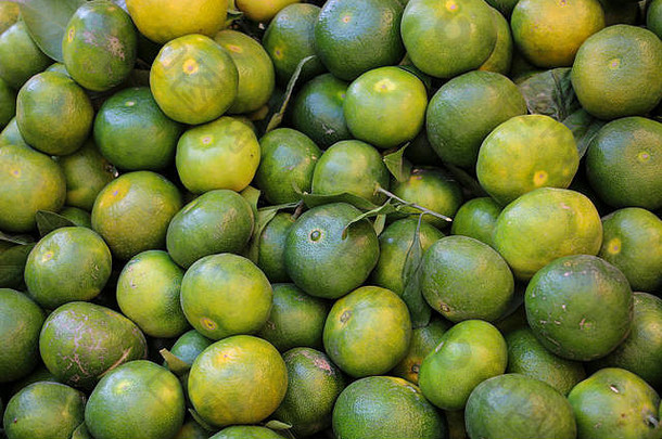 伊朗西北部卡兹温市场柜台上长着叶子和细枝的<strong>绿</strong>色柑桔