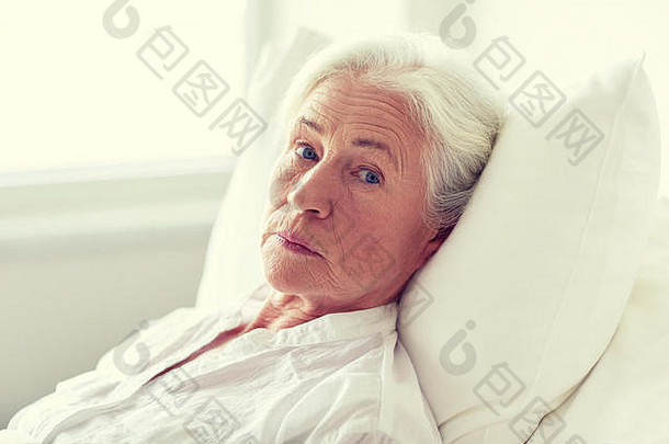 躺在医院病房病床上的老年女病人