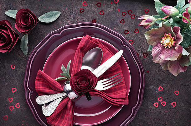 平放着勃艮第的盘子和装饰着玫瑰和海葵的陶器，圣诞或情人节餐桌