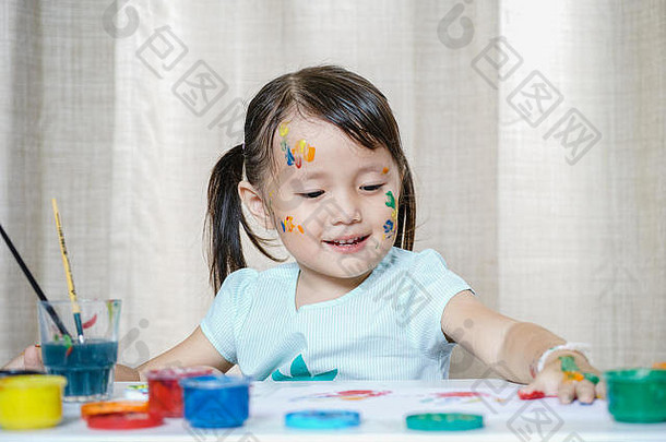 小女孩用画笔和彩色颜料绘画儿童发展观