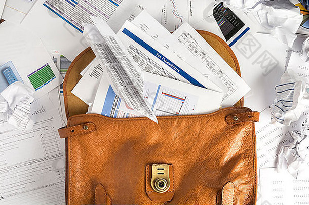 概念图显示公文包打开，装满了可用于税务或其他财务报道的文件