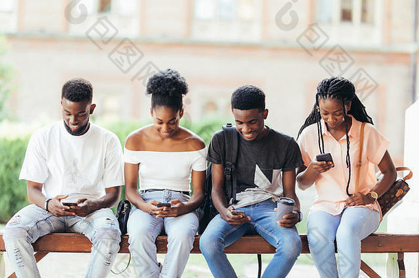 一群非洲学生在户外使用多种科技设备建立网络