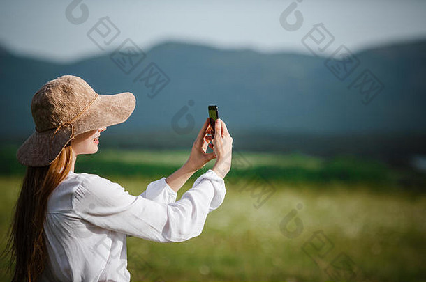 妇女在户外使用手机。使用智能手机导航路线搜索、拍照和自拍