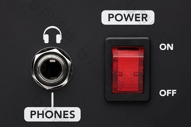 黑色放大器上的<strong>电源</strong>开关<strong>按钮</strong>和耳机输入插孔。听音乐而不打扰别人。特写细节。