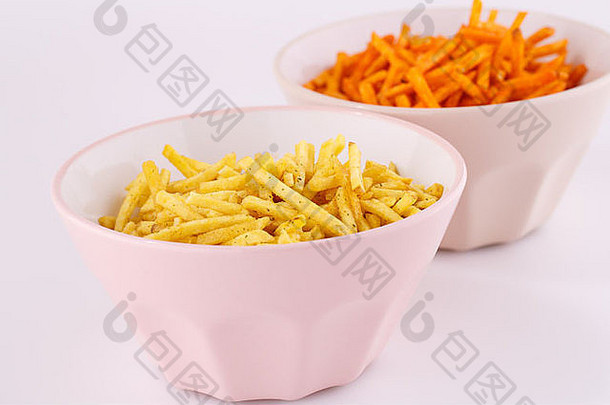 粉红色和米色碗中的薯<strong>片</strong>，在灰色背景上分开。