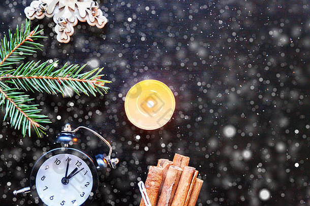 圣诞新年构图框架由<strong>冬季</strong>物件制成，冷杉枝装饰蜡烛钟，黑色背景。平放俯视图空间。圣诞节十二月是庆祝的时间