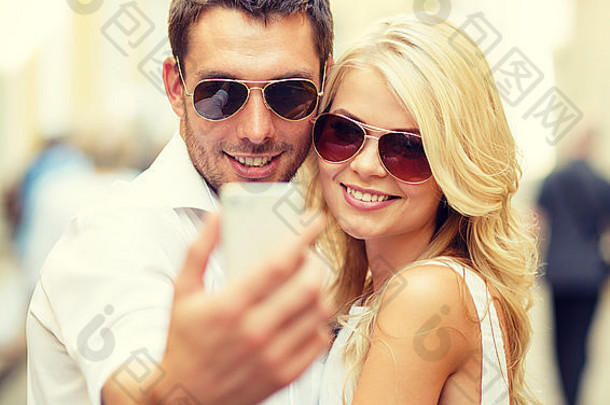 城市里带着智能手机的微笑情侣