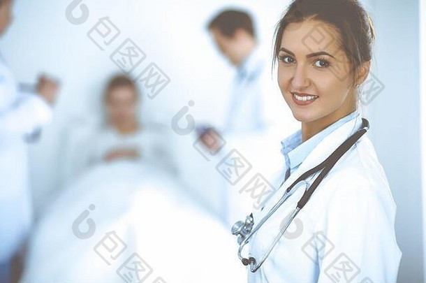 女医生在床上微笑，病人和两名医生在床上