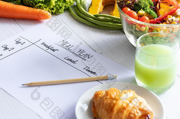 热量控制，膳食计划，饮食和减肥概念。纸上用餐<strong>计划表</strong>的俯视图，包括沙拉、果汁、面包和蔬菜
