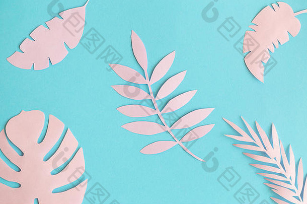 淡色粉红色的热带树叶，由隔离在蓝色自然图案上的纸制成。