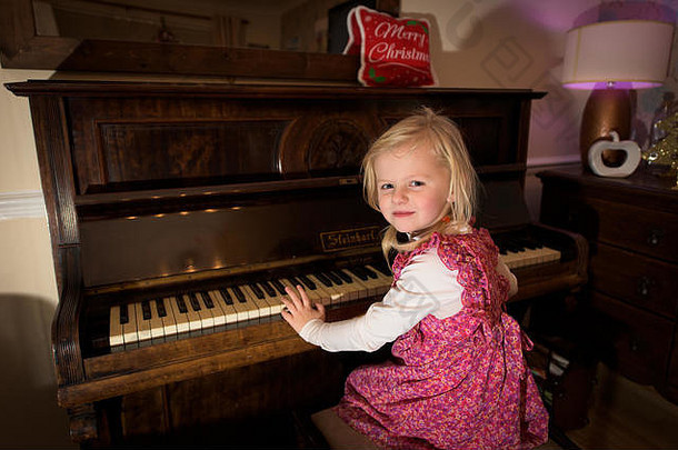 一个可爱的小<strong>女孩</strong>在家里练习钢琴，小音乐家为她的家人表演