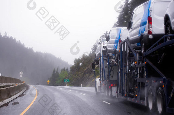 强大的车搬运工半卡车运输汽车特殊的两级预告片绕组高速公路山多雨的天气