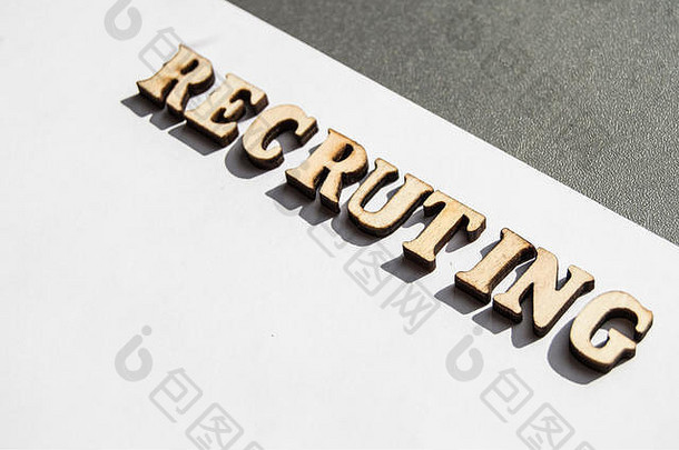 “招聘”一词是用白色背景上的木制字母书写的，它的概念是雇佣员工，在商业和中招聘