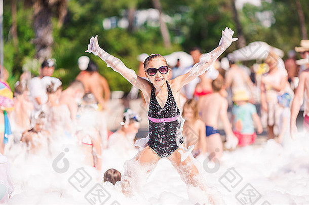 海滩上的泡沫派对。可爱的小女孩，玩得开心，跳舞。