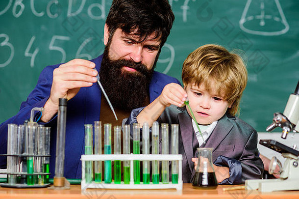 父亲和儿子在学校。生物技术研究概念。回到学校。向孩子解释生物学。有胡子的男老师和小男孩。化学和物理生物学。让我们用化学药品。
