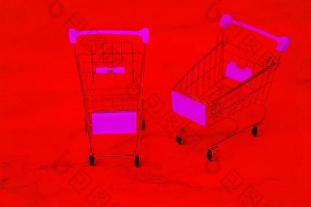 不锈钢购物车。金属<strong>超市</strong>购物车。红色背景上的两个空购物手推车。购物理念。