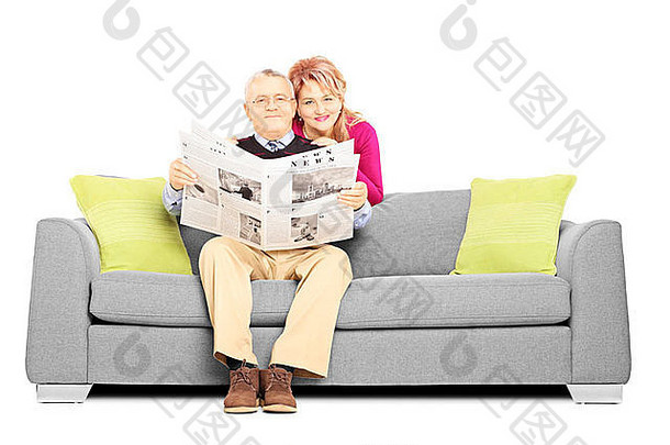 中间岁的夫妇报纸坐着沙发