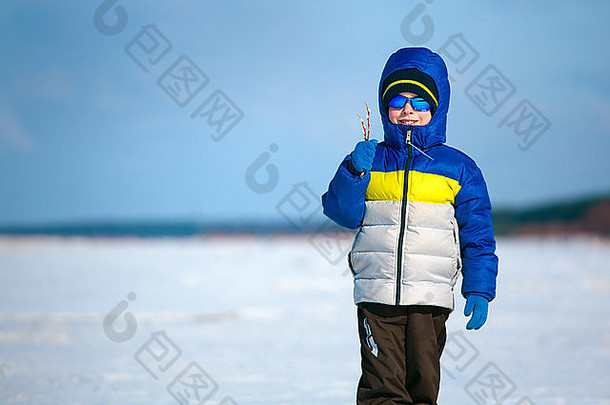 可爱的男孩在户外站冬天海滩