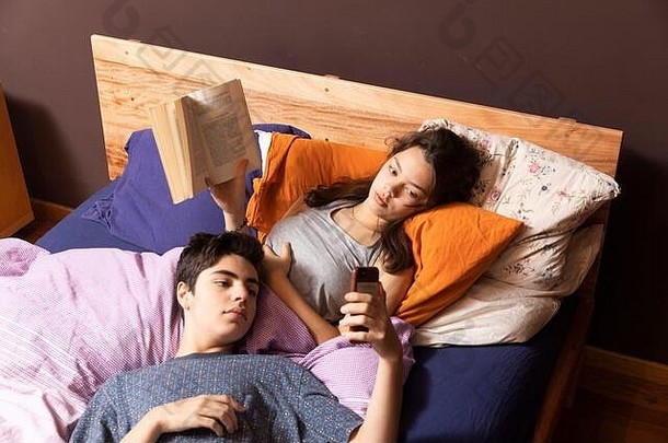 年轻的夫妇说谎床上书电话