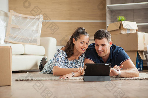 这对刚搬入<strong>新居</strong>的夫妇正在通过平板电脑在线购买家具