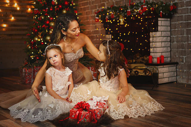妈妈和女儿们穿着奢华的圣诞礼服。节日装饰。相关的感觉。礼品。友好的家庭。一起度过时光。