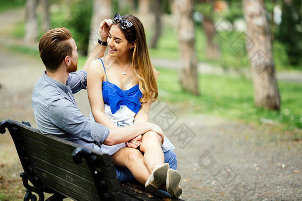 相爱的情侣在公园的长椅上享受大自然