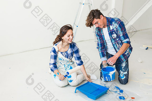 重新装修，色彩，装修和人的概念-夫妇去油漆墙壁，他们正在混合颜色