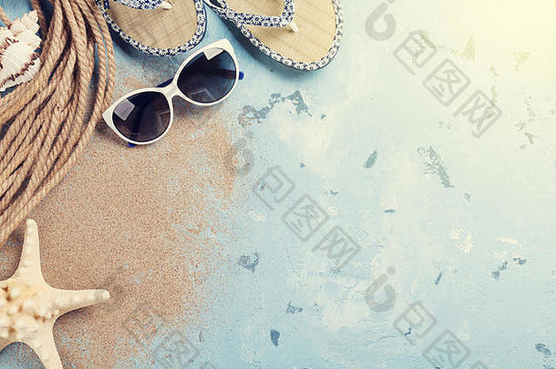 海滩配件。石头背景上的太阳镜、人字拖和贝壳。具有空间的俯视图。阳光明媚