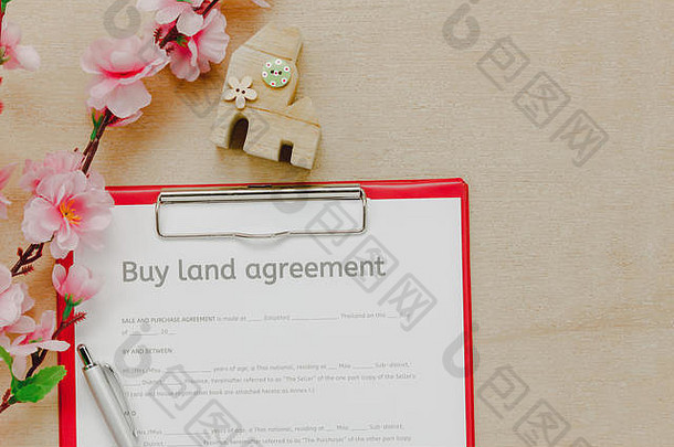 俯视商务办公桌背景。该企业购买土地价格表铅笔木房子美丽的粉红色花在木桌背景与c