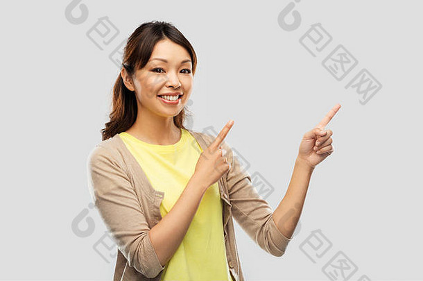 快乐亚洲女人指出手指